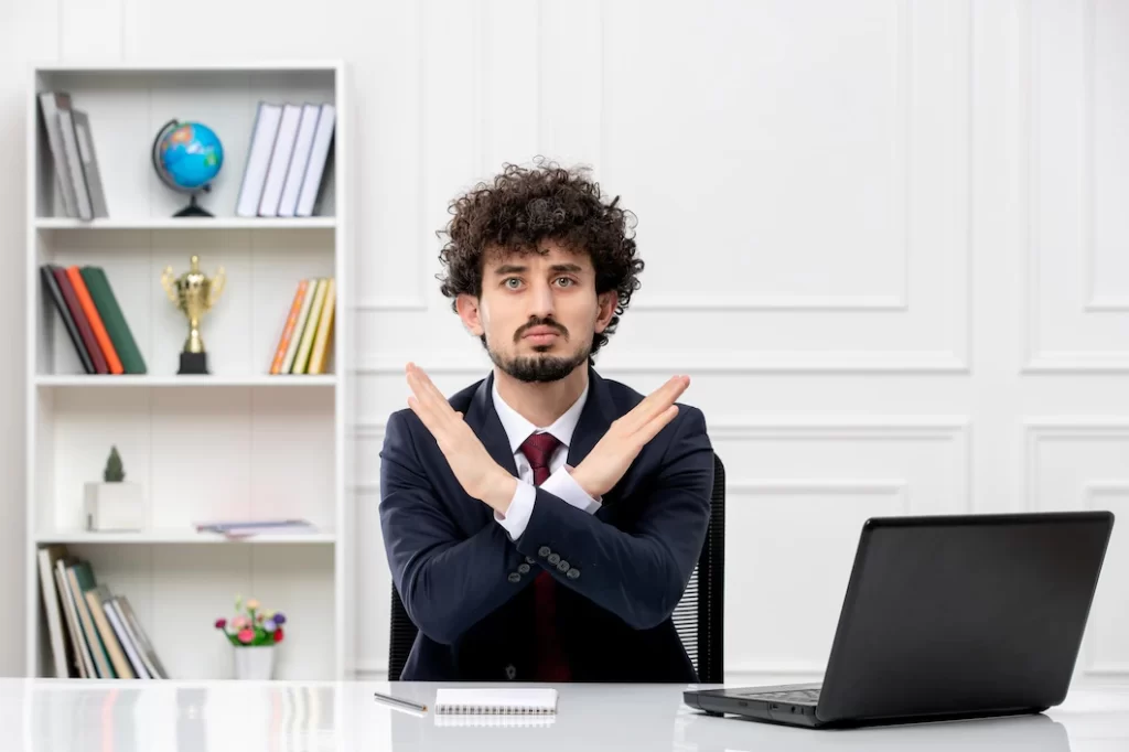 deny an job offer Man sitting on desk with laptop denying job offer by recruitment agency